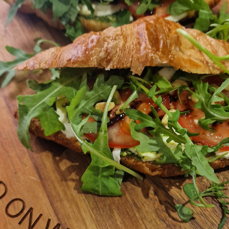 Roomboter croissant Caprese (mozzarella, tomaat, rucola, basilicum, pesto en pijnboompit)